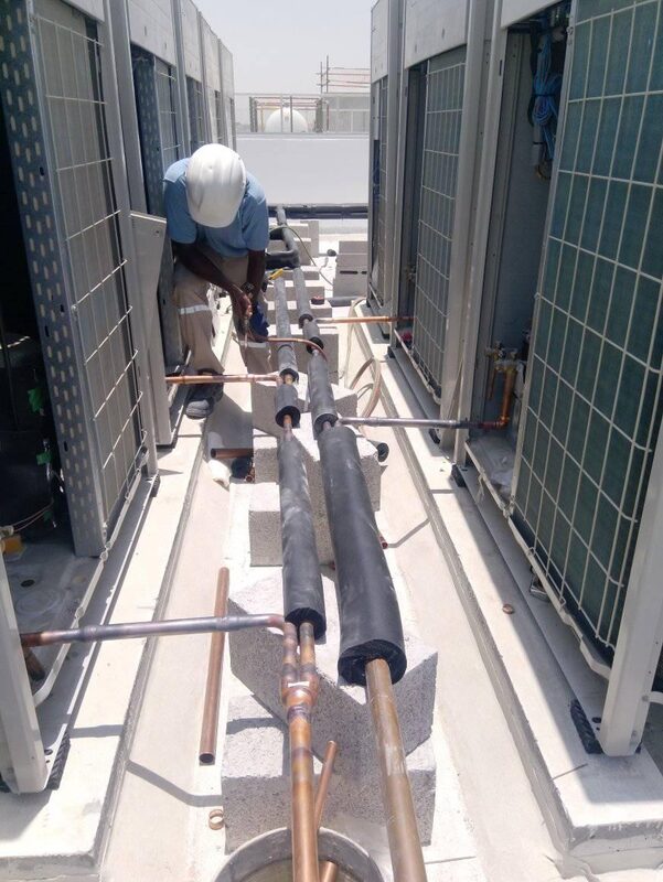 Technician working on large commercial rooftop AC installation